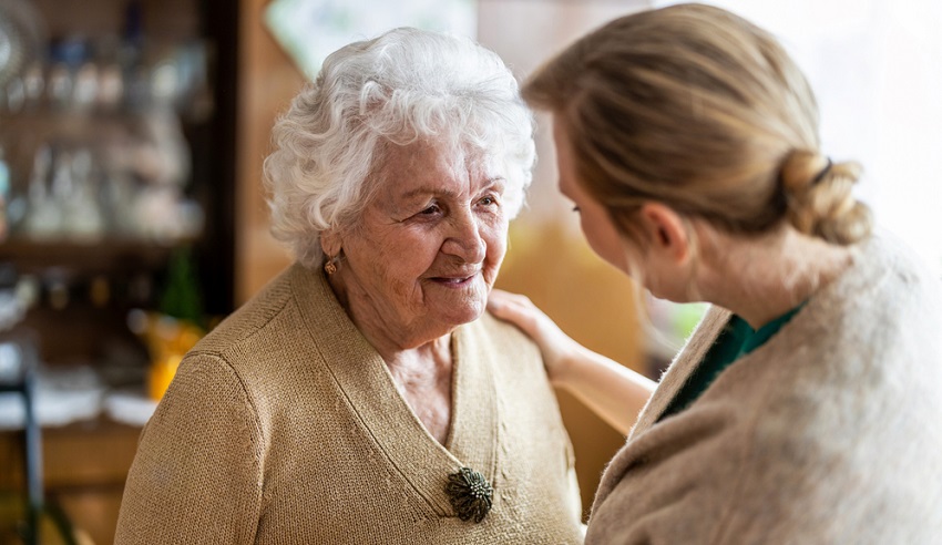 health visitor talking to a senior woman during home visit