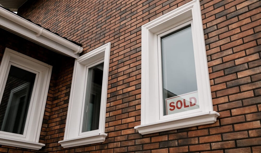 sold sign on the window of a house