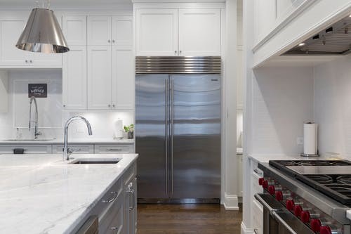 stainless steel fridge in a white wall kitchen